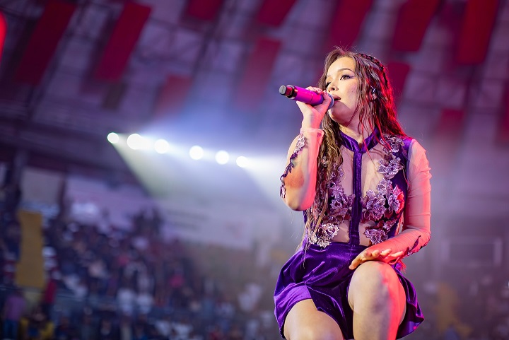 Kiara Lozano canta sobre el escenario durante el concierto Acceso al Corazón 2 de Corazón Serrano en 2024.